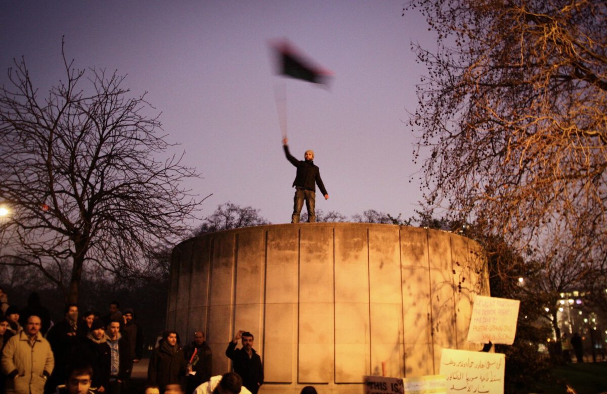Libya's uprising protest, London, UK, Man waving the Libyan flag in front of the Libyan Embassy in London.