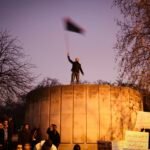 Libya's uprising protest, London, UK, Man waving the Libyan flag in front of the Libyan Embassy in London.