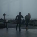 two men walking against the wind in Iceland, gloomy weather.