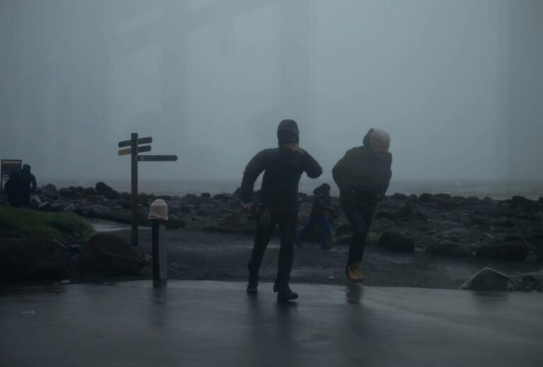 two men walking against the wind in Iceland, gloomy weather.