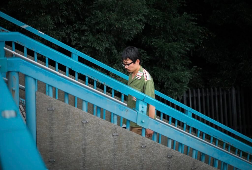 Japanese man climbing stairs, overcast day in Tokyo, Japan.