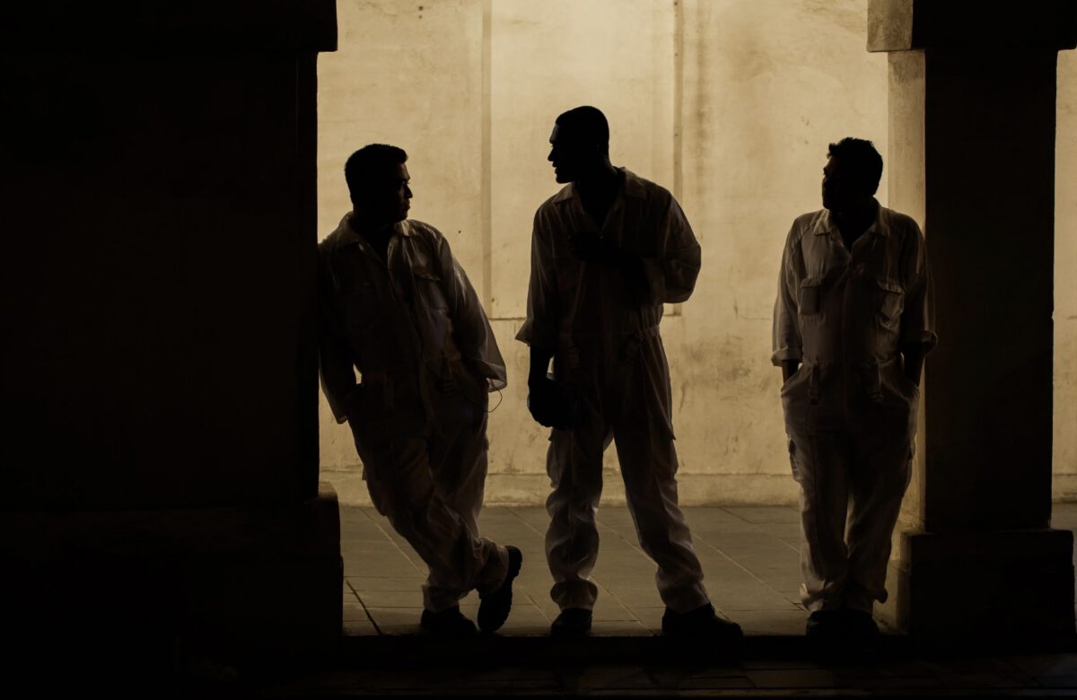 three men standing in Doha's souq waqig at night, beautiful silhouettes.