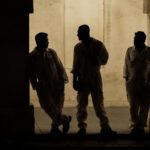 three men standing in Doha's souq waqig at night, beautiful silhouettes.