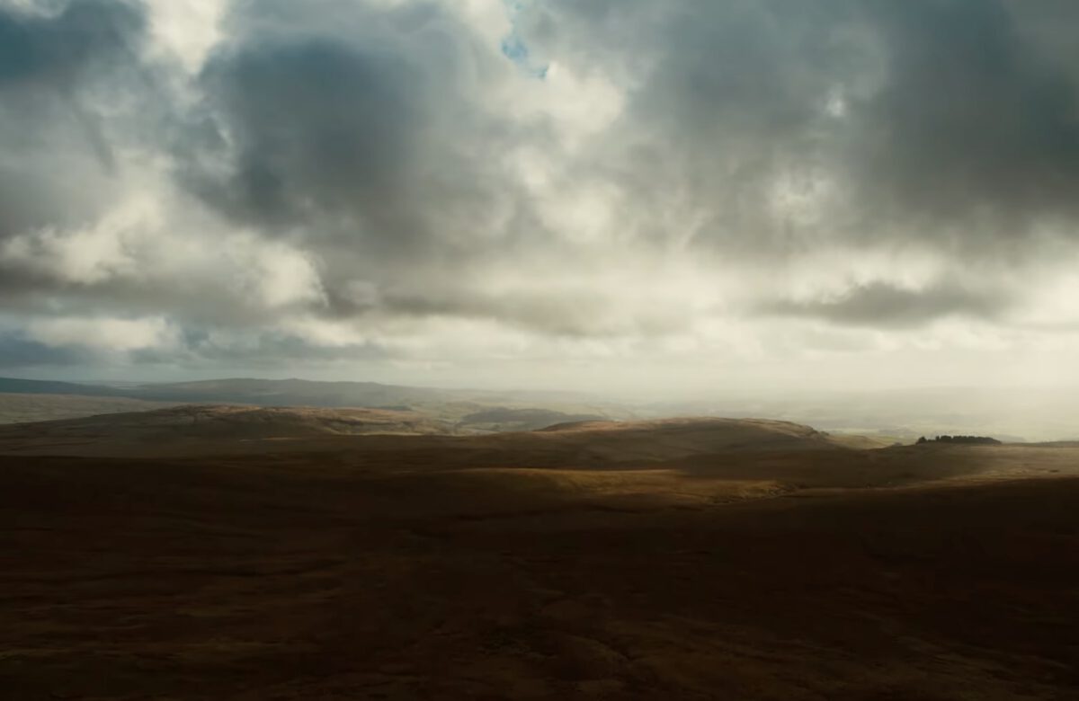 A drone shot of the English countryside, atmospheric lighting, rolling hills, beautiful views from above.