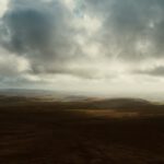 A drone shot of the English countryside, atmospheric lighting, rolling hills, beautiful views from above.