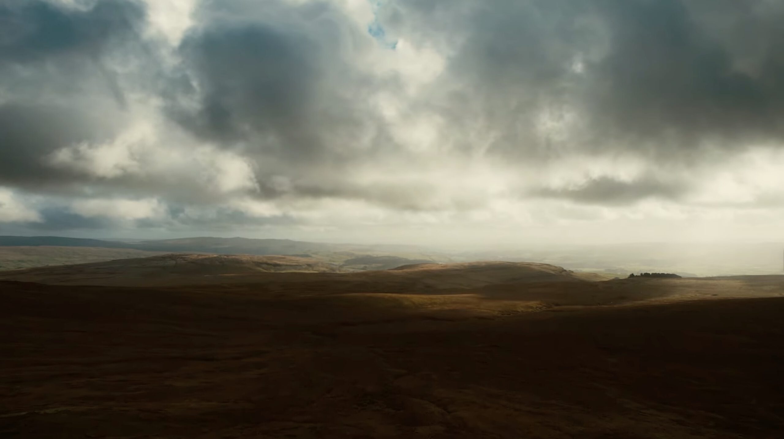 A drone shot of the English countryside, atmospheric lighting, rolling hills, beautiful views from above.