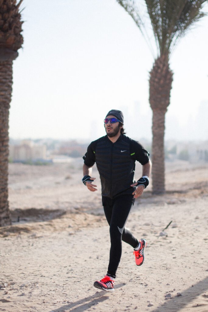 Fahad Khalid Al-Thani running along a dusty outdoor track during a commercial brand shoot.