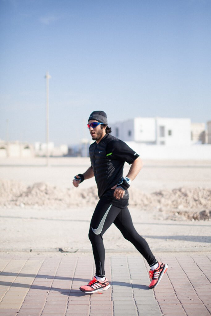 Fahad Khalid Al-Thani running along a dusty outdoor track during a commercial brand shoot.