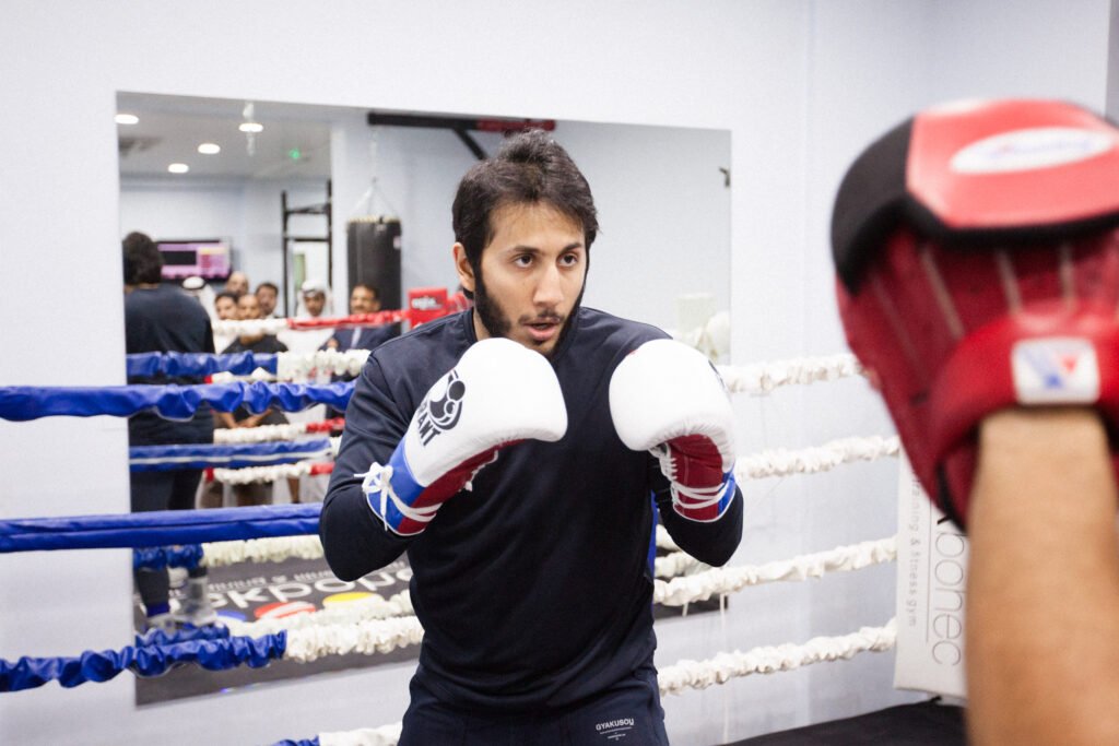 Fahad Khalid Al-Thani training with his coach at the gym during a lifestyle brand photoshoot.